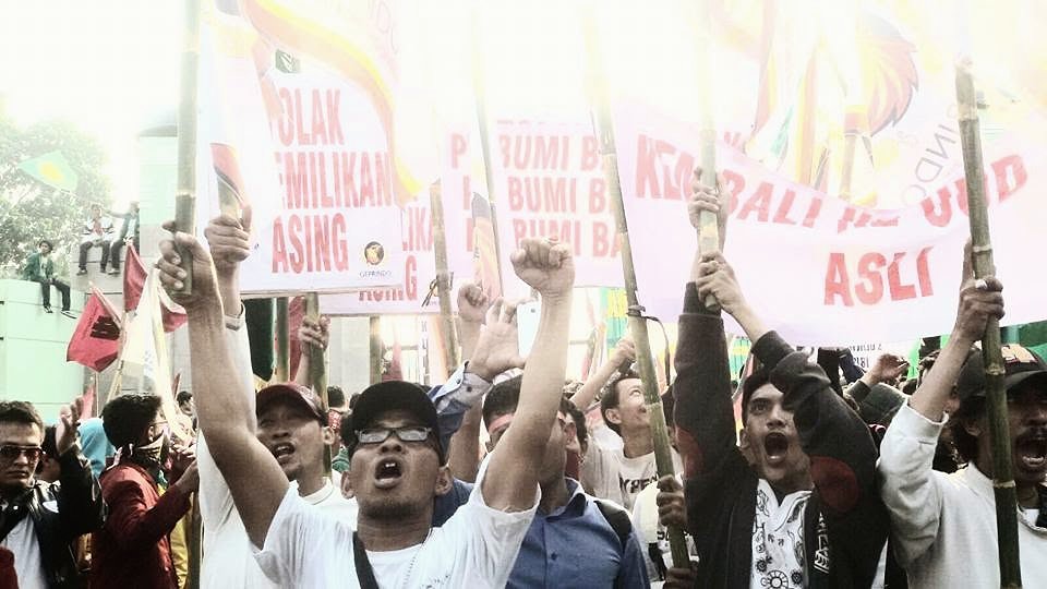 Peserta aksi mengangkat kepalan tangan dan spanduk tuntutan