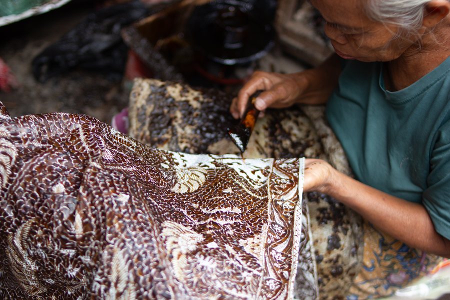Perajin batik membentuk pola dengan canting di Trusmi, Cirebon.